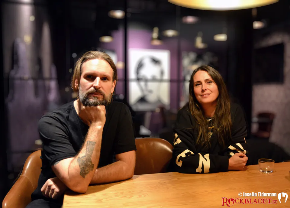 Två bandmedlemmar sitter vid ett bord under en intervju